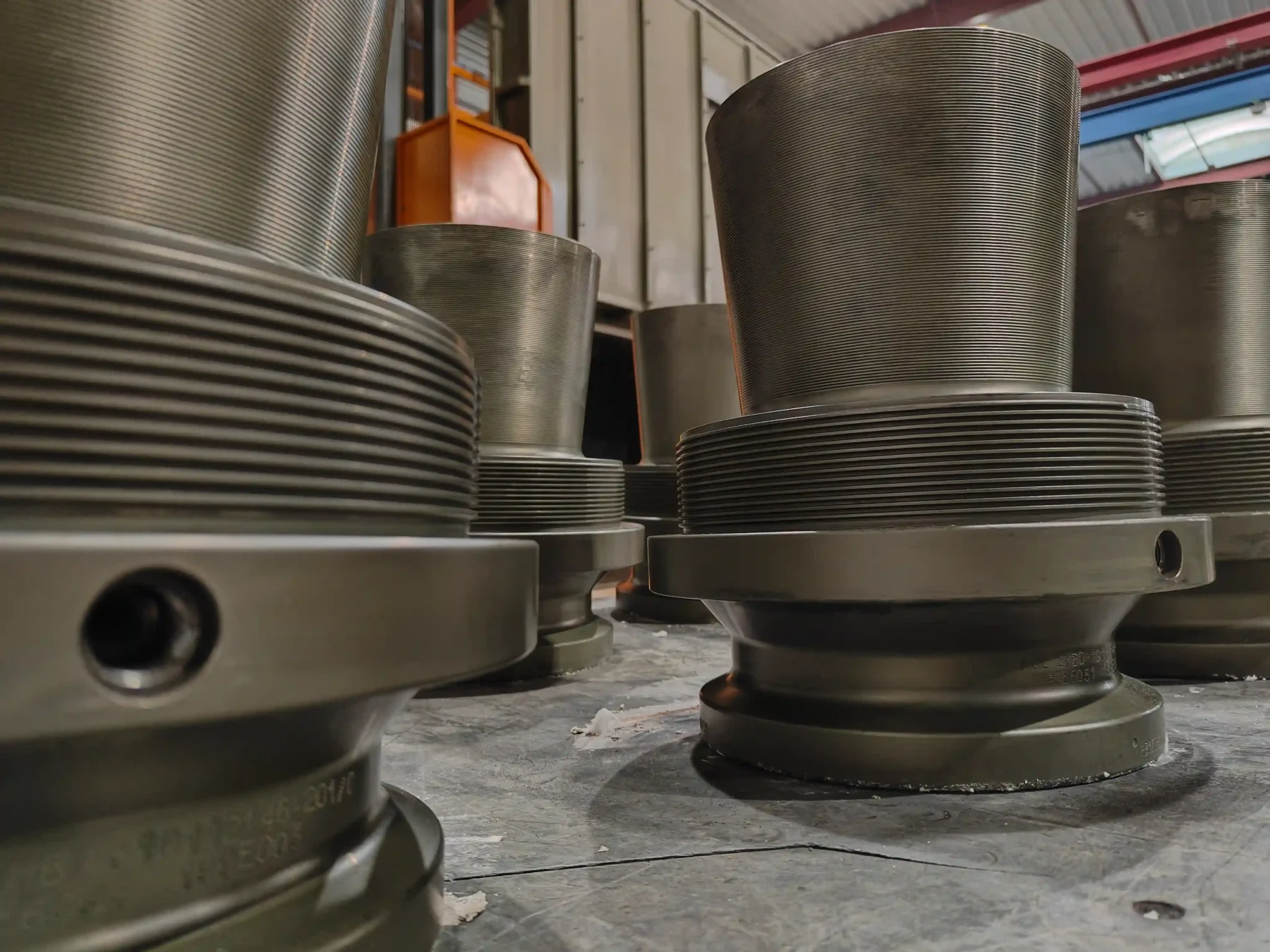 Pièce mécanique en métal, de forme cylindrique avec détails techniques et perçages, ayant subit un traitement thermique de diffusion après nickelage.